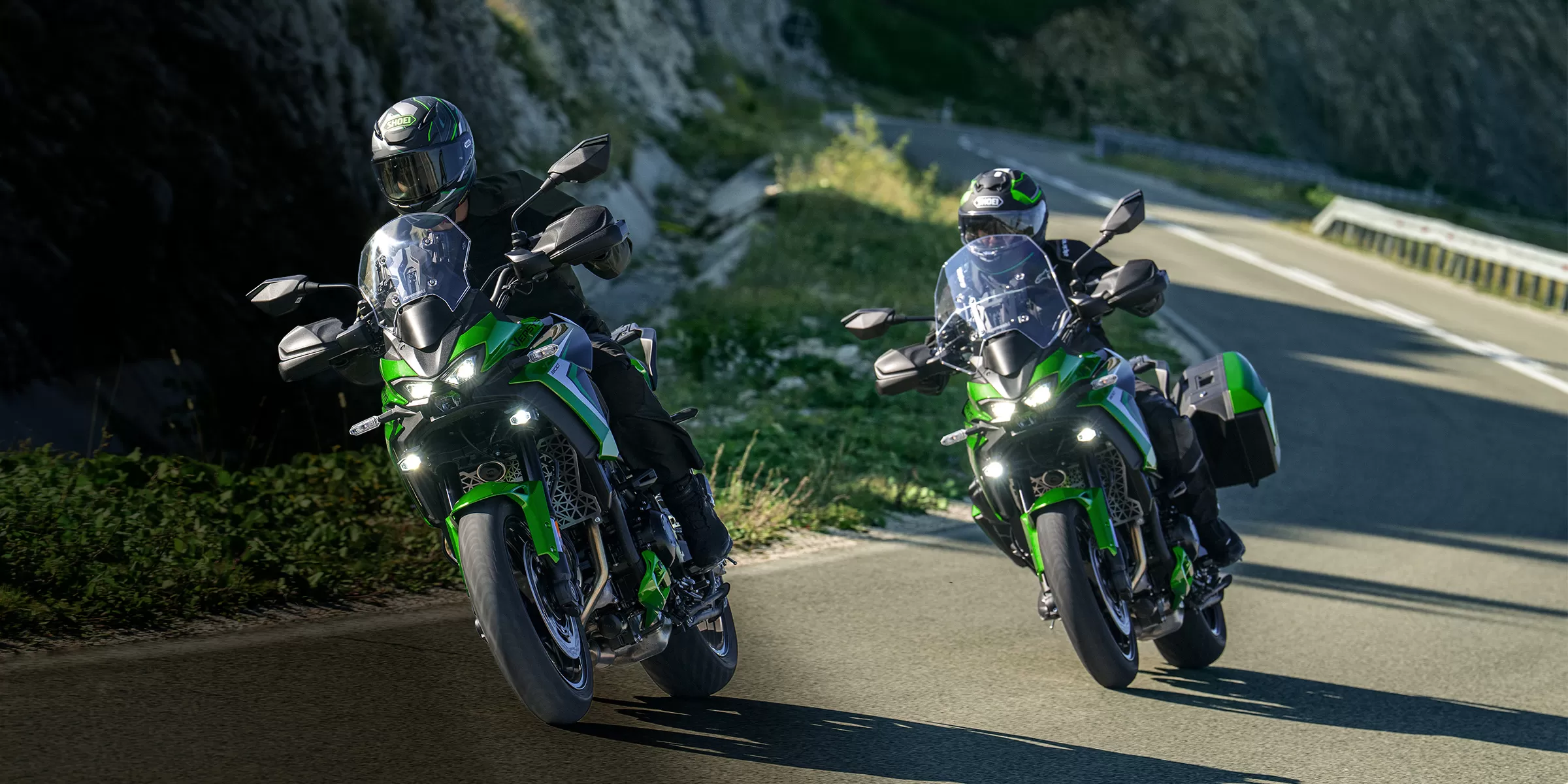 Kawasaki Versys 900 SE parked on a mountain track as the rider walks towards it