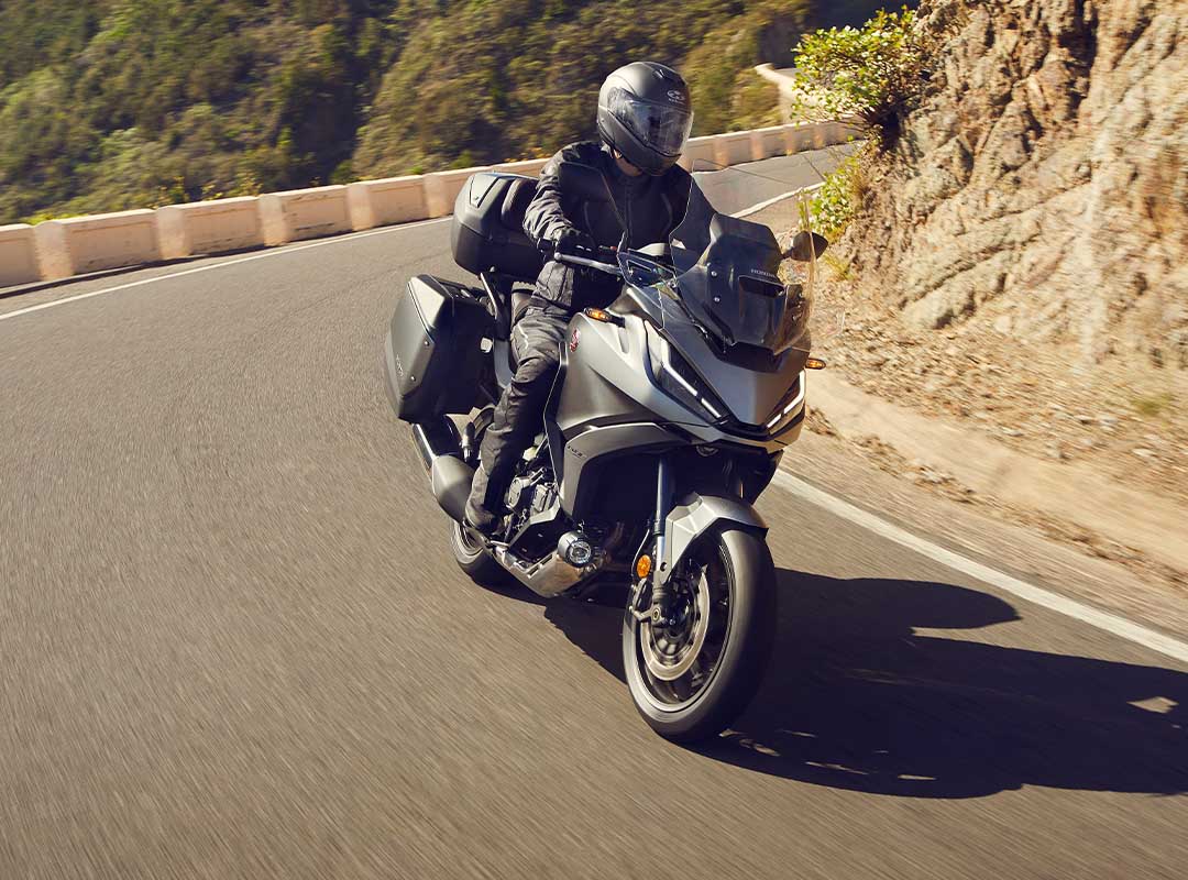 Guy riding the NT1100 over a mountain