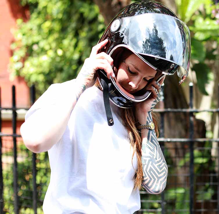 Steph Bolam putting on her motorcycle helmet