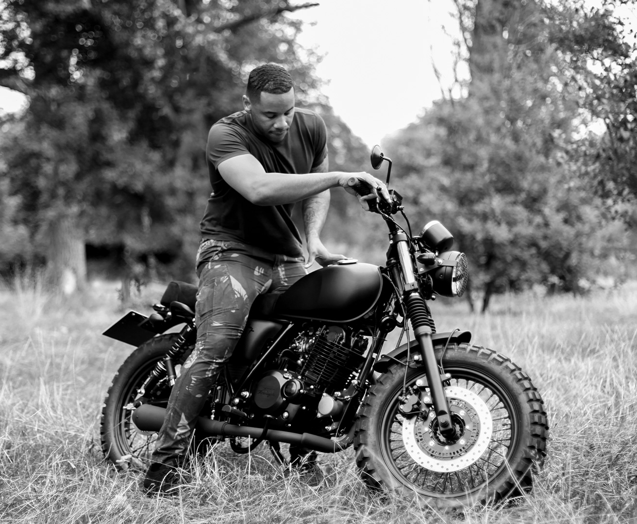 Reggie Yates sitting on his new Mutt Motorcycles Custom Brat