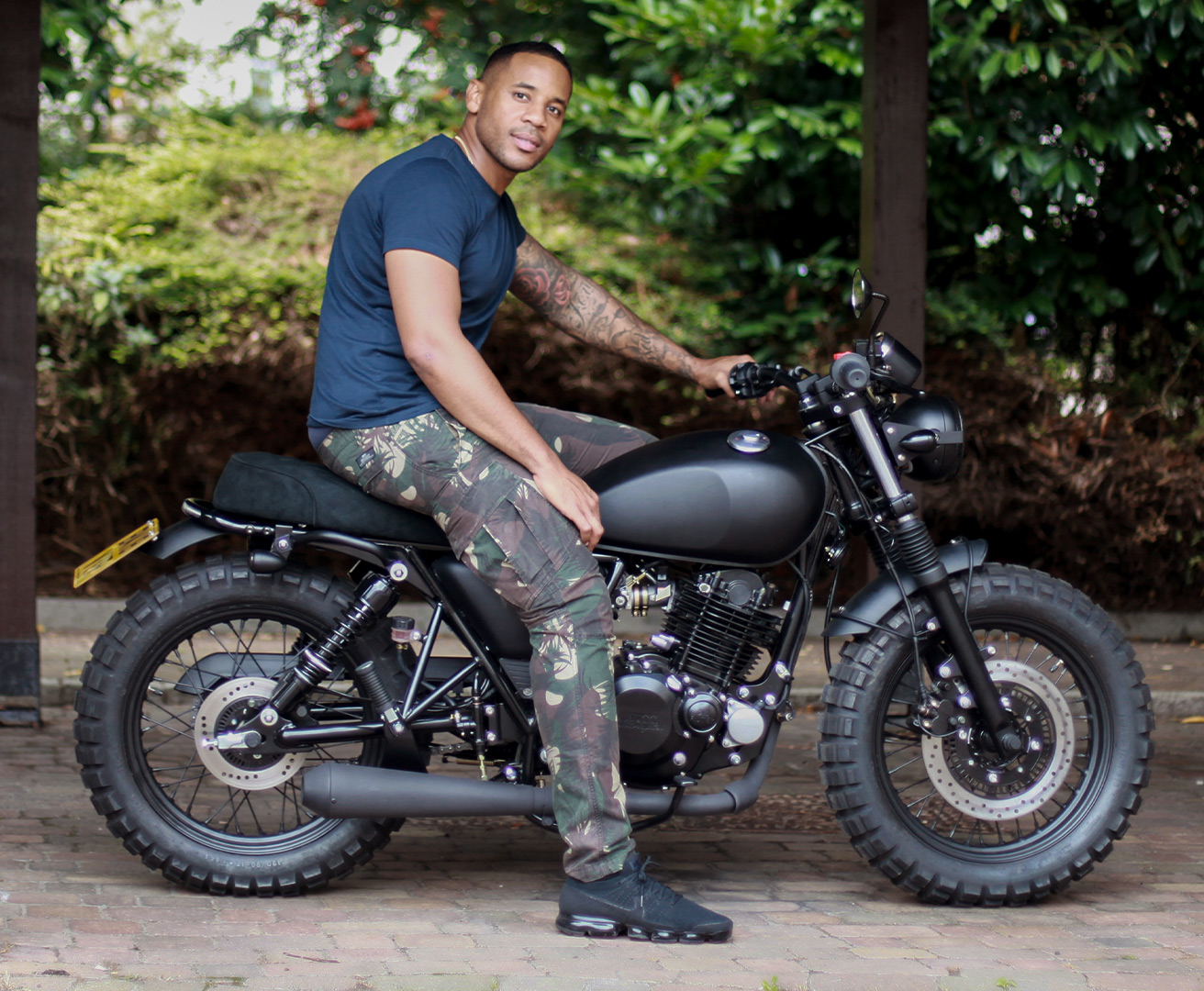 Reggie Yates sitting on his new Mutt Motorcycles Custom Brat Bob