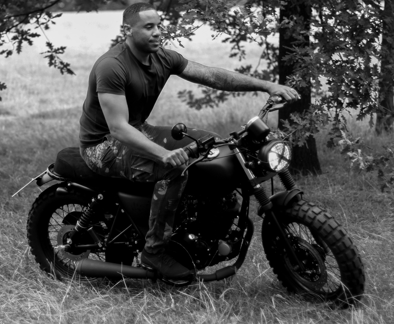 Reggie Yates sitting on his new Mutt Motorcycles Custom