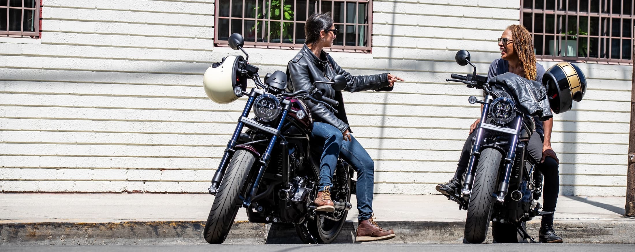 Two ladies riding Honda motorcycles